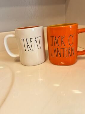 Rae Dunn Halloween set of 2 mugs that say “trick/treat” and “jack O lantern”
